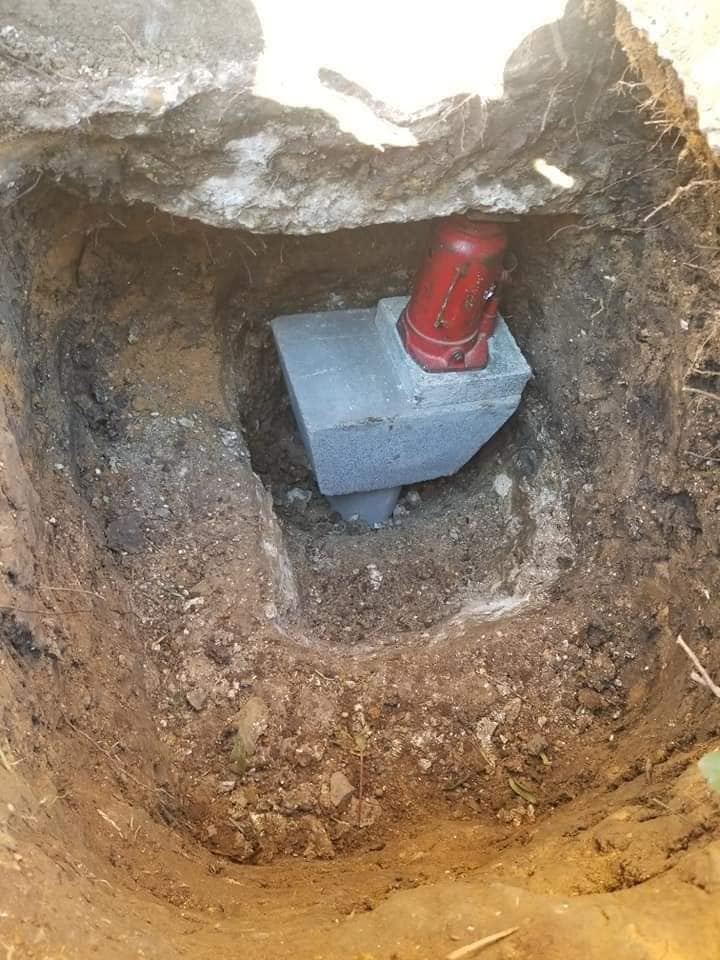 Hydraulic jack and concrete cap supporting a foundation